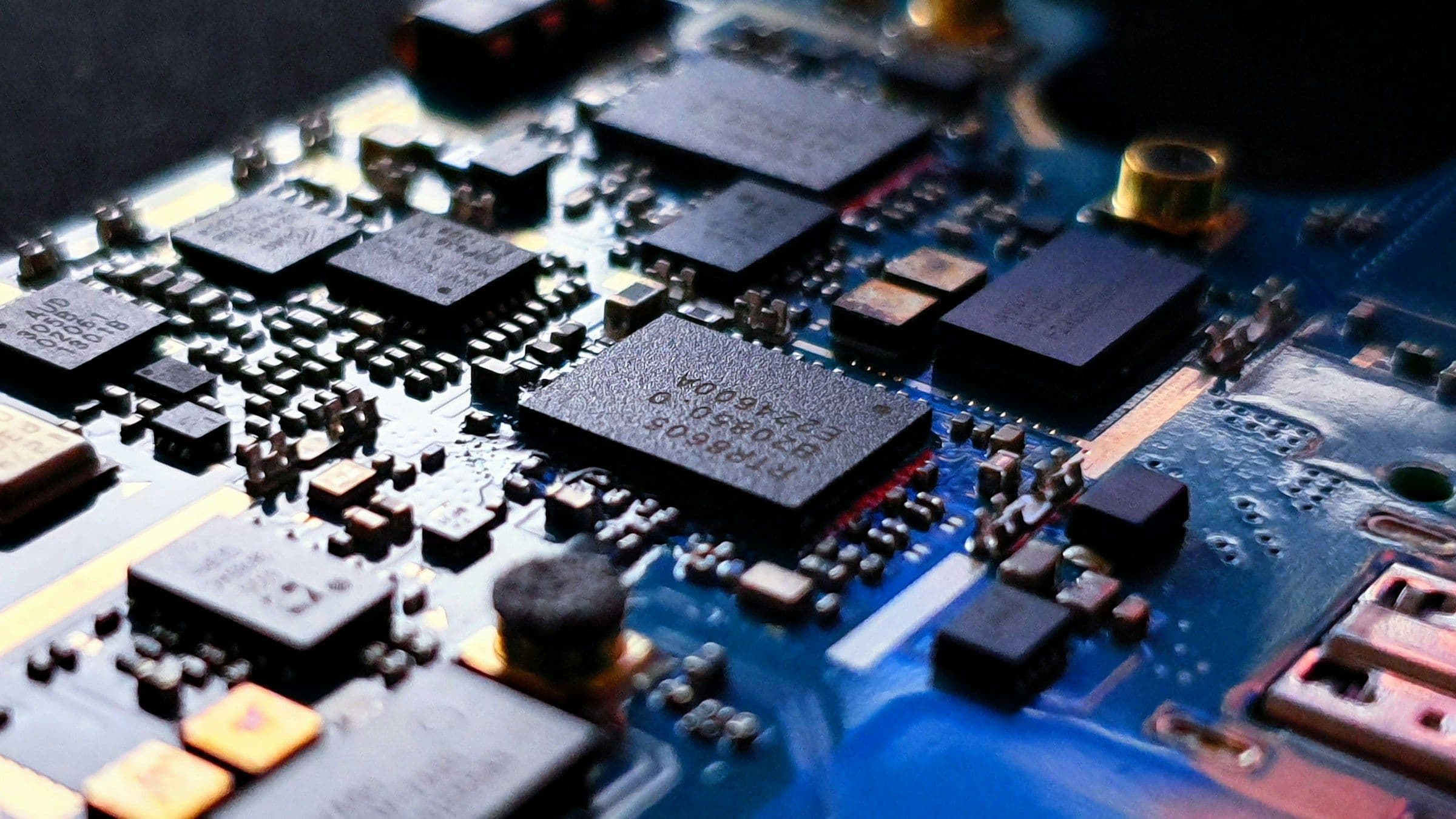 A circuit board in close-up, its components lit from one side