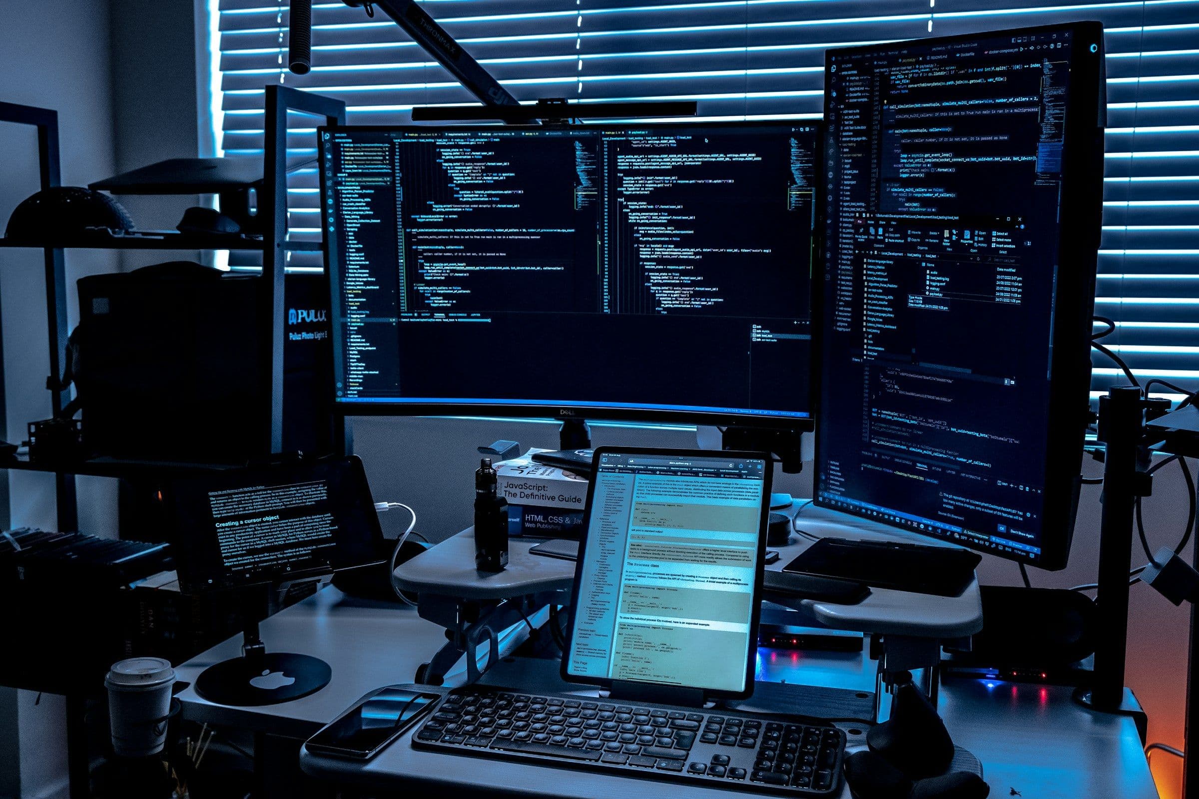 A desk of monitors showing system activity